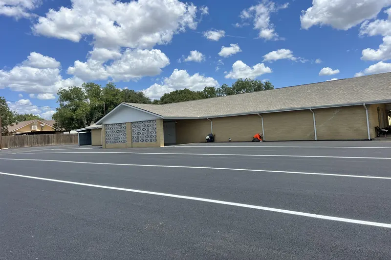Freshly paved and striped commercial parking lot under a blue sky