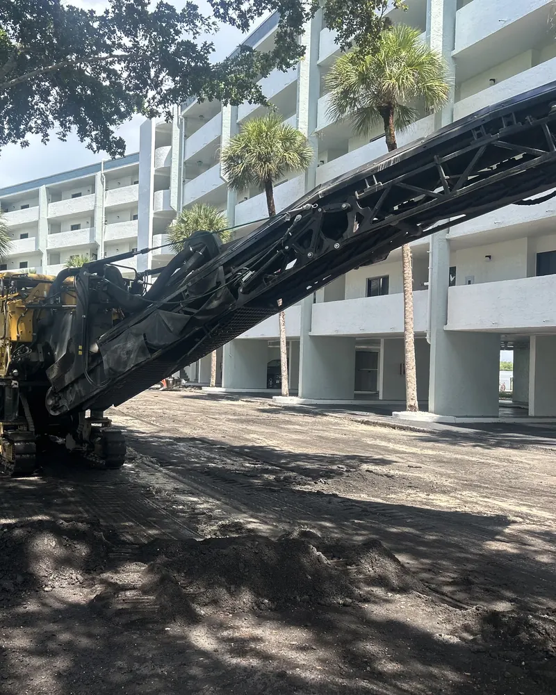 Milling machine removing worn asphalt at a condominium before repaving