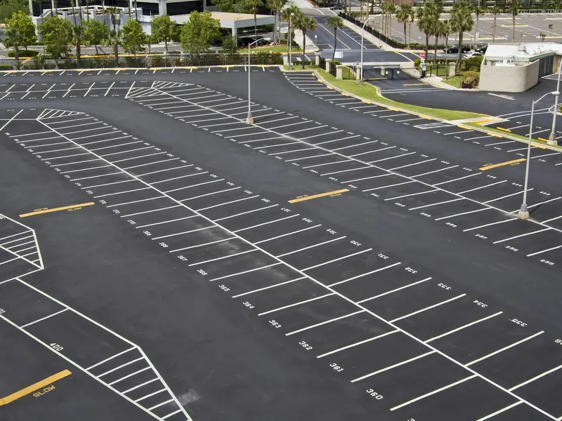 Newly paved and striped parking lot lined with palm trees